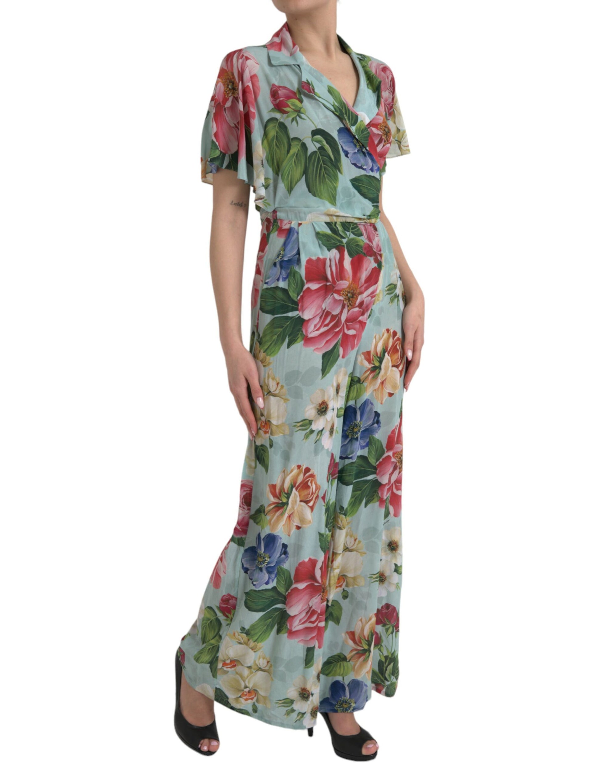A woman wearing a blue floral wrap jumpsuit dress with wide legs