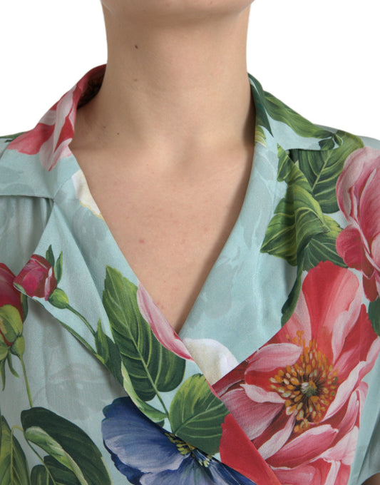A woman wearing a blue floral wide leg jumpsuit dress with a V-neckline