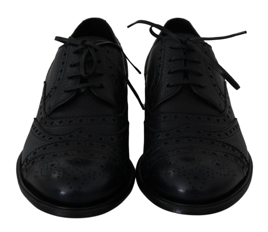 Pair of black dress shoes with laces and a bow tie
