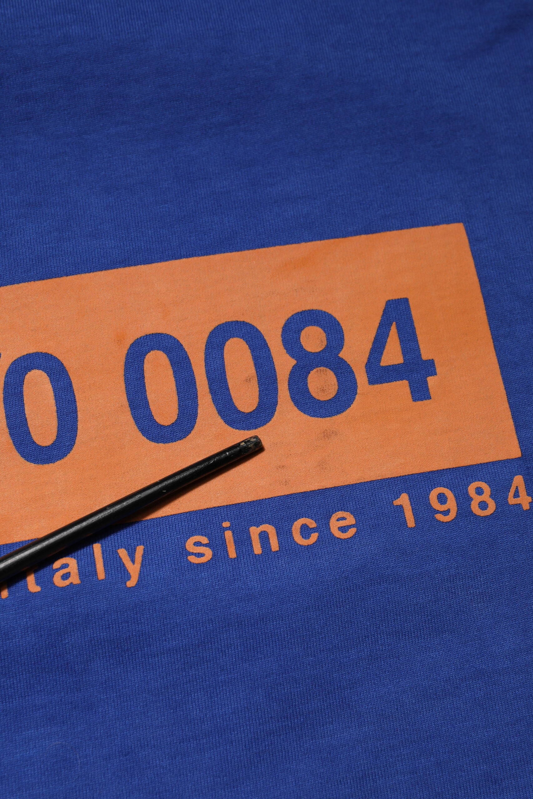 Blue shirt with orange numbers on it