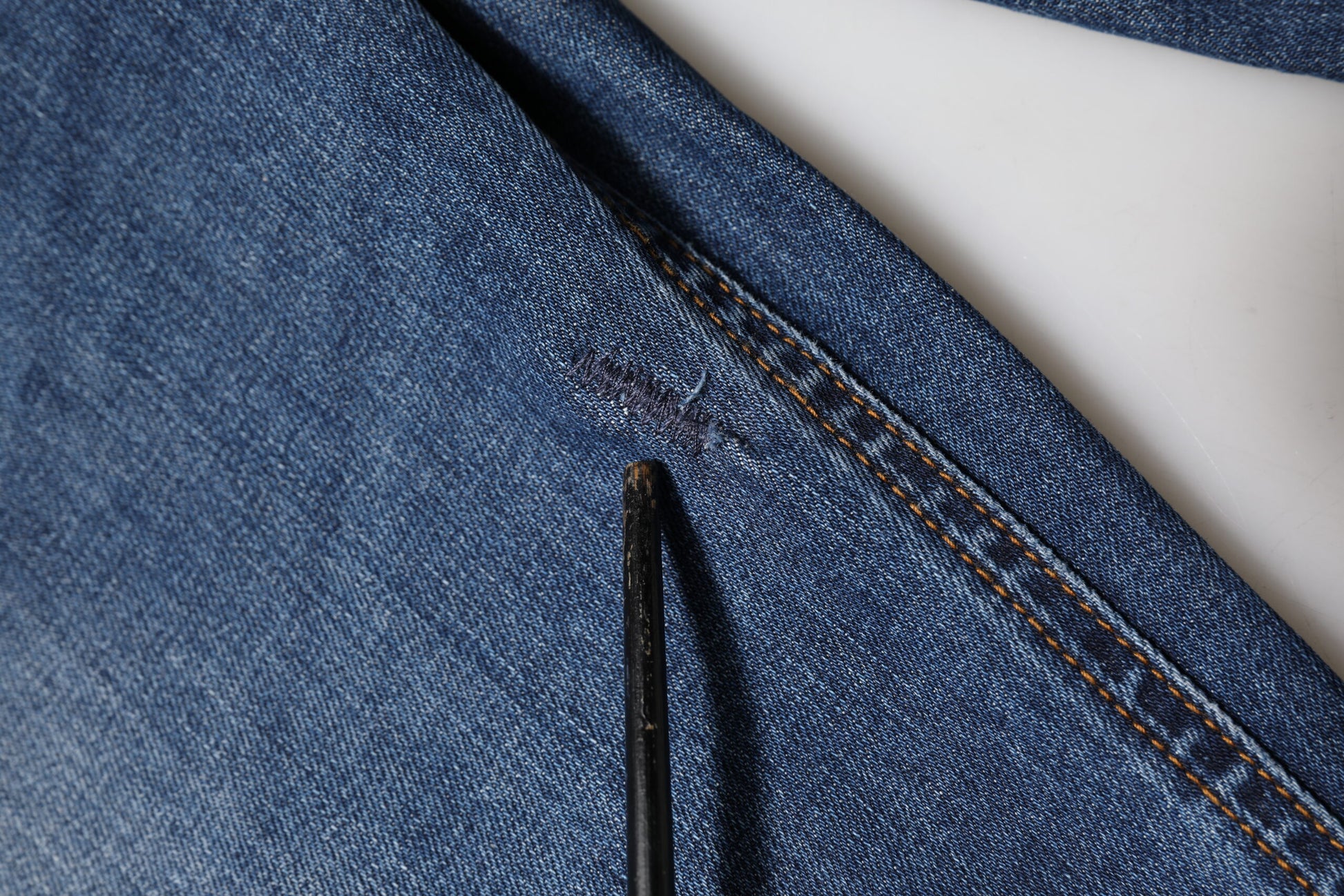 Blue denim jeans on a white paper background