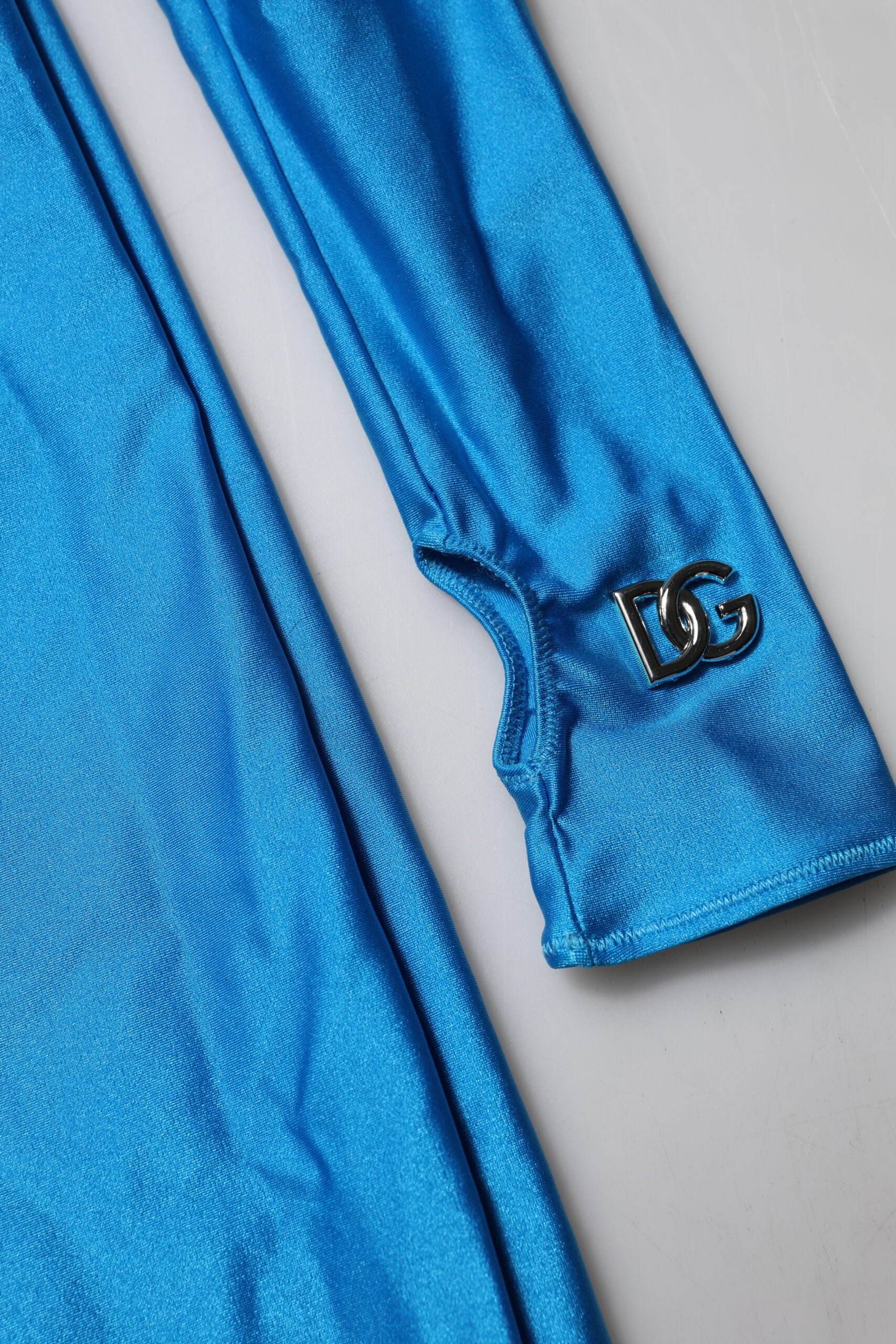 A blue nylon turtleneck jumpsuit dress with a logo on the left sleeve