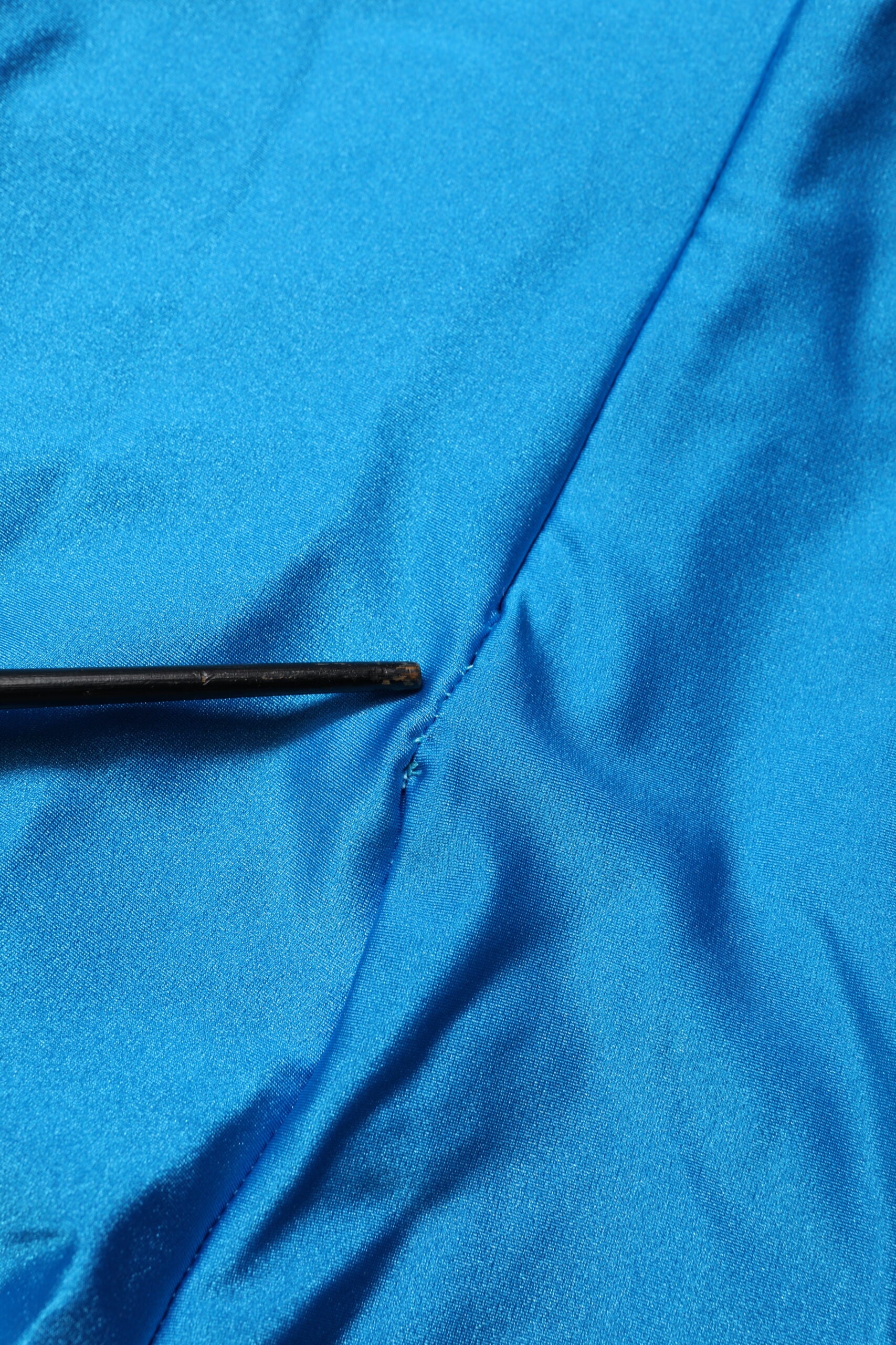 A blue nylon turtleneck jumpsuit dress with a body-hugging fit
