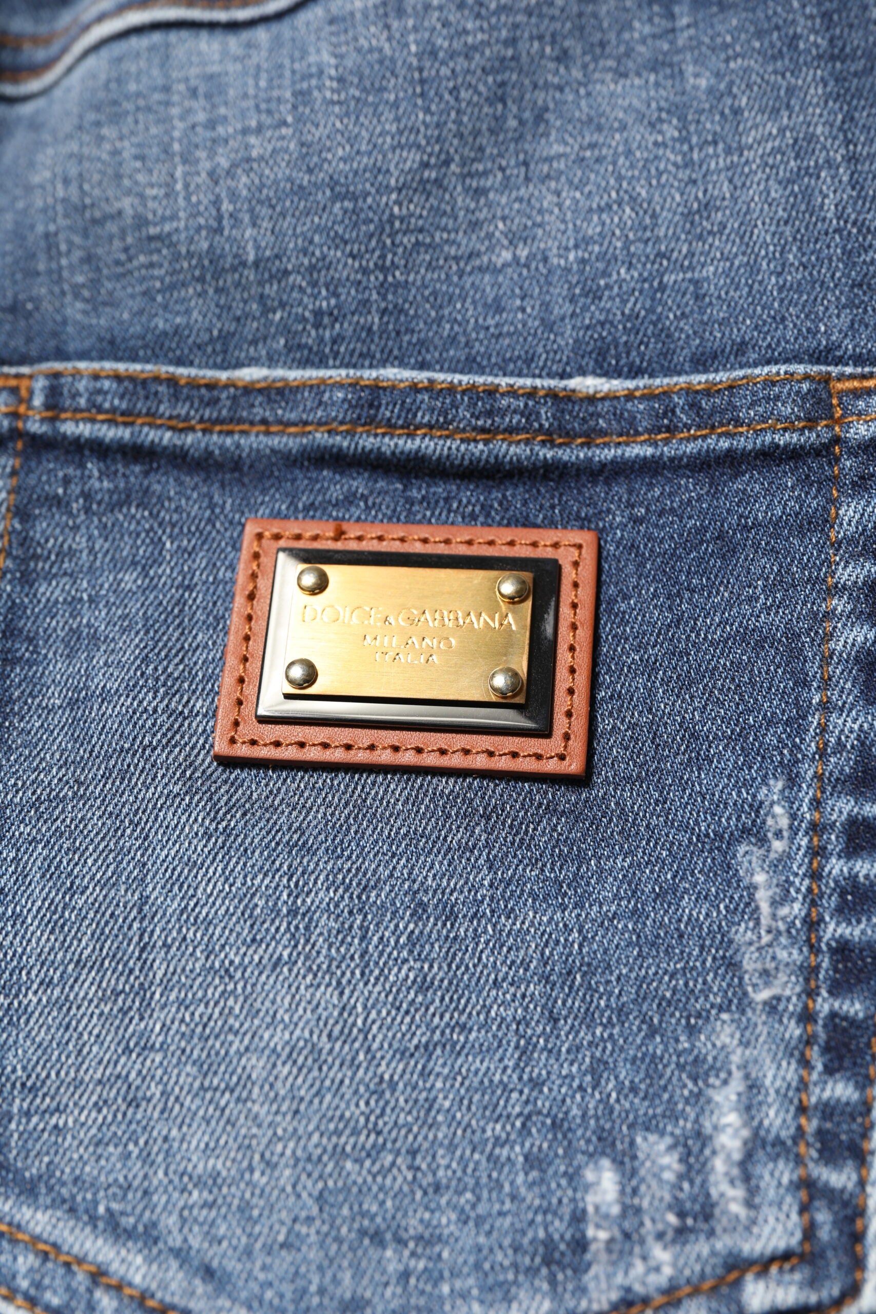 Blue denim jeans with a brown leather patch on the back pocket