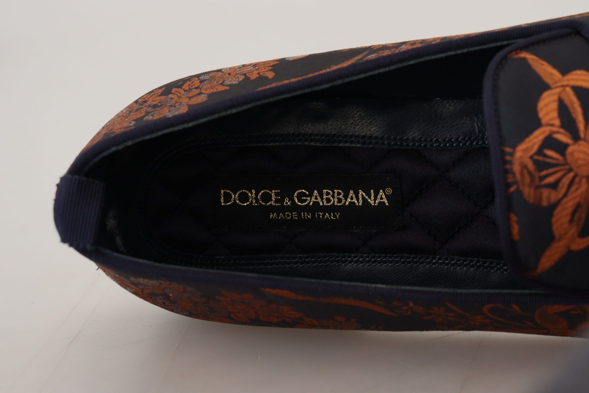 Black and orange shoe with floral design on inner lining