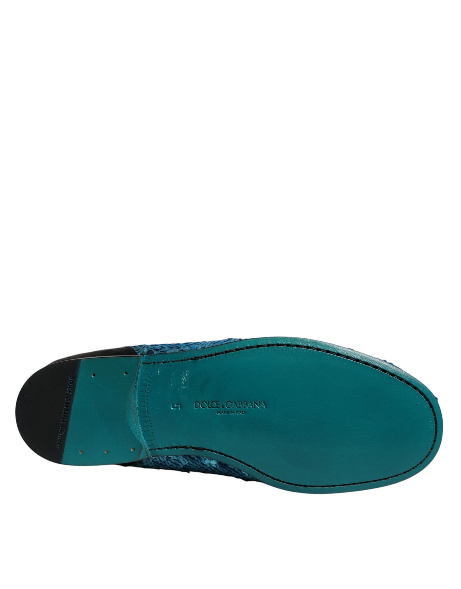 A single blue sequined loafer shoe with a black heel and toe cap
