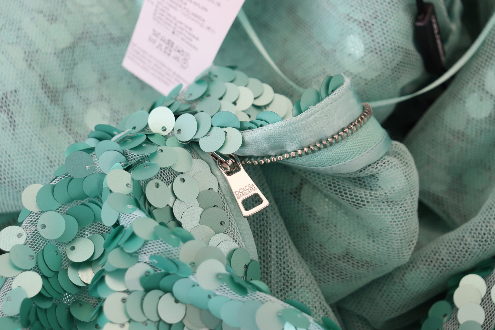 A green sequined dress with pleats and a zipper in the front