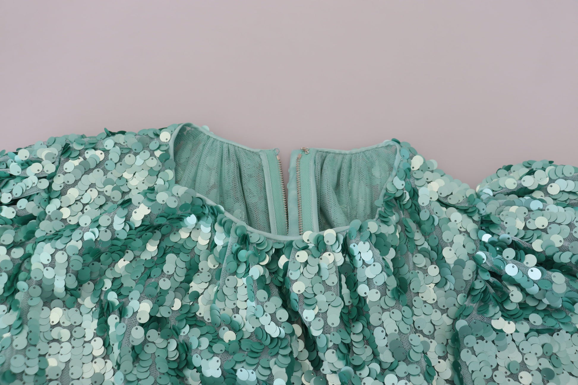 A green sequined dress with pleats and a V-neckline