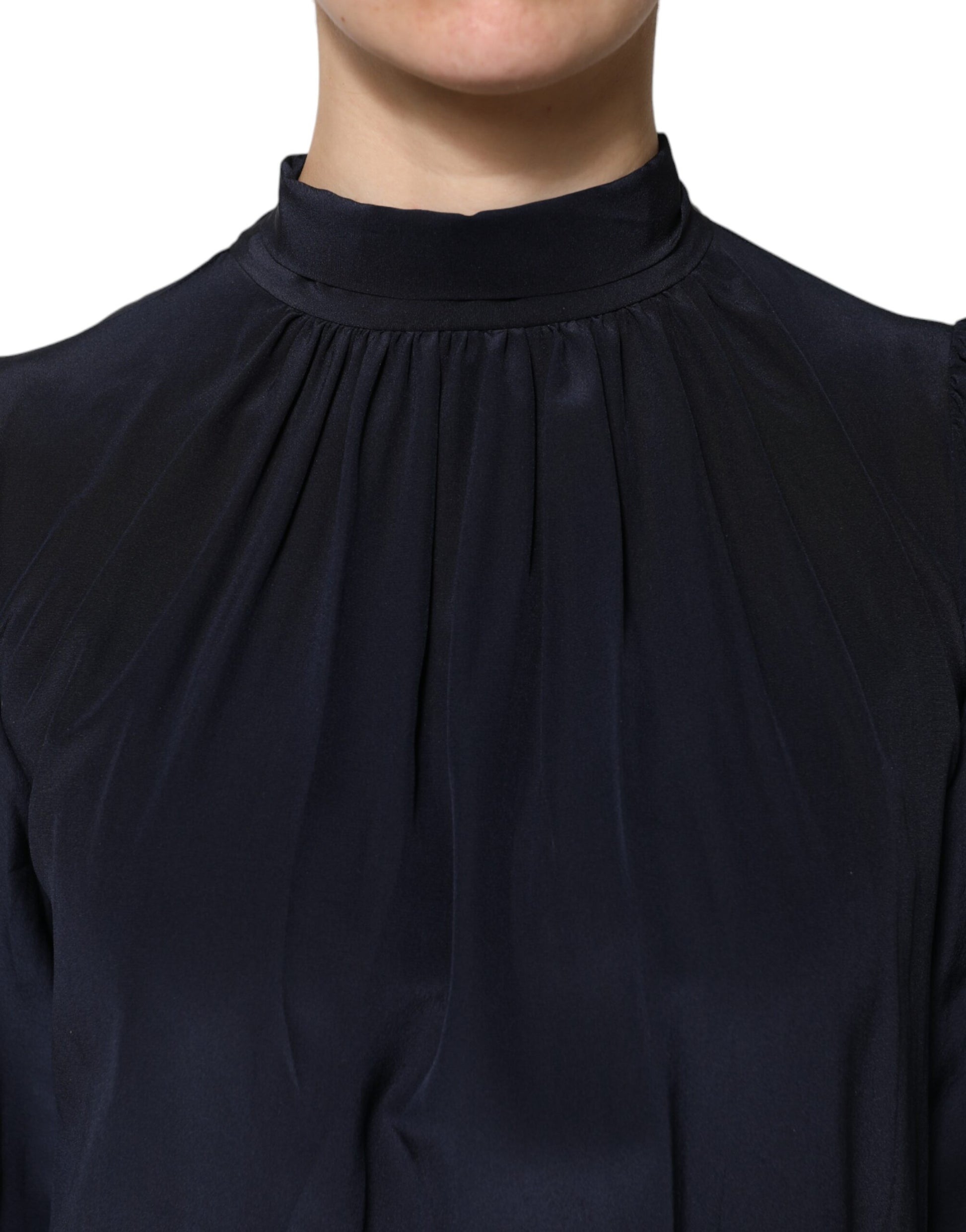 Woman wearing dark blue shirt with ruffled neckline