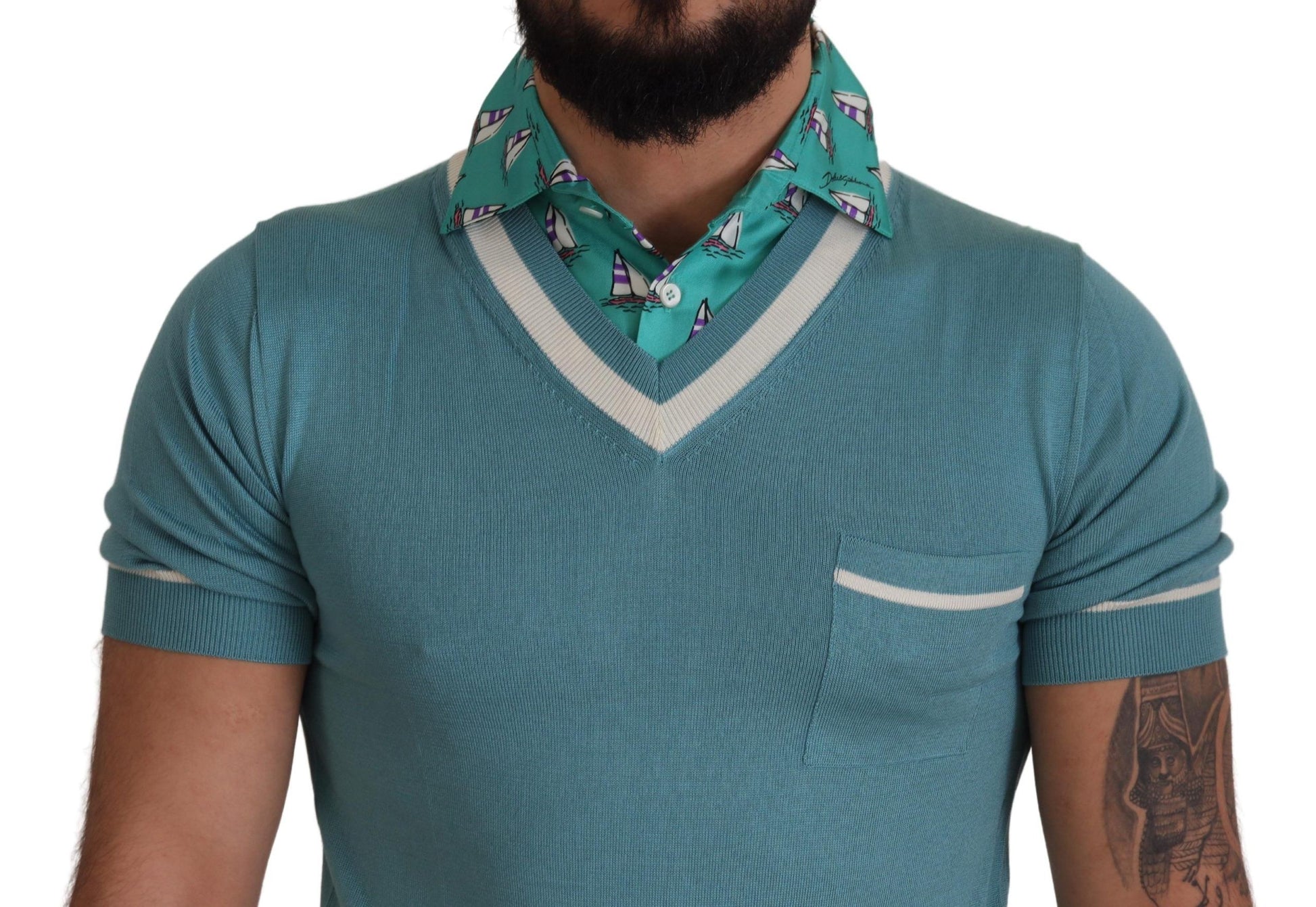 Mannequin torso wearing blue sweater vest with white trim and a patterned scarf