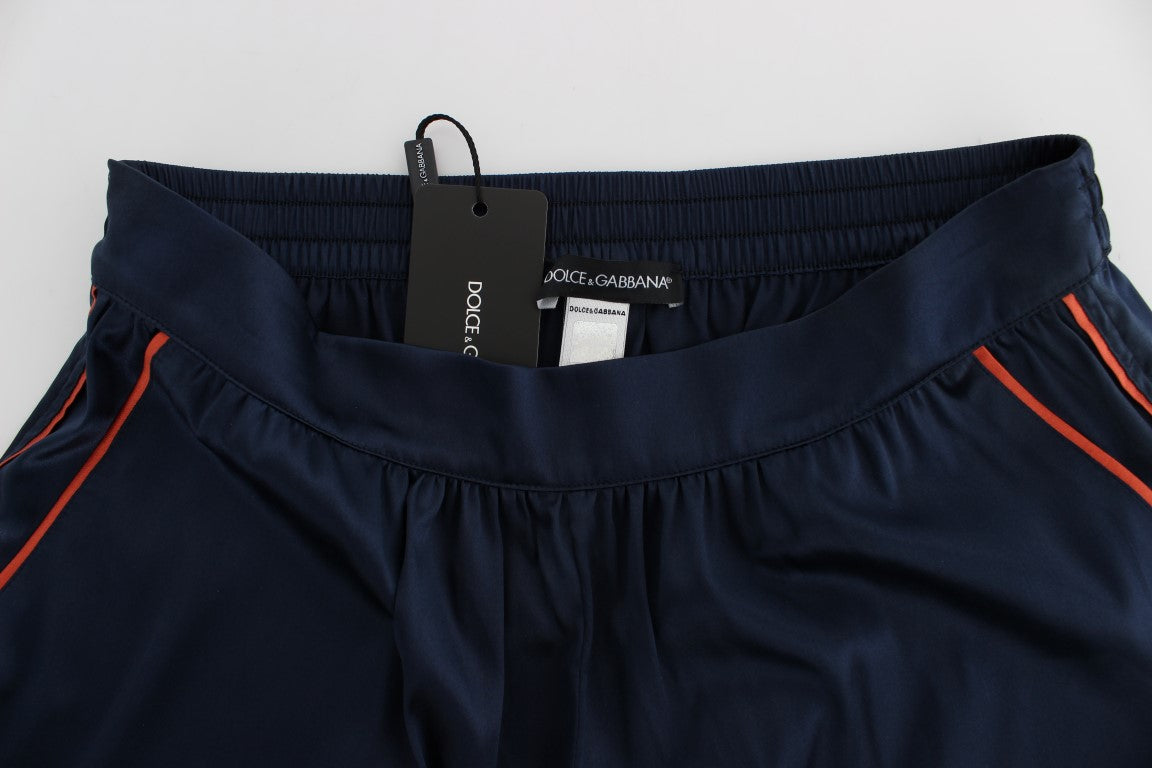Navy blue pants with orange trim on a hanger