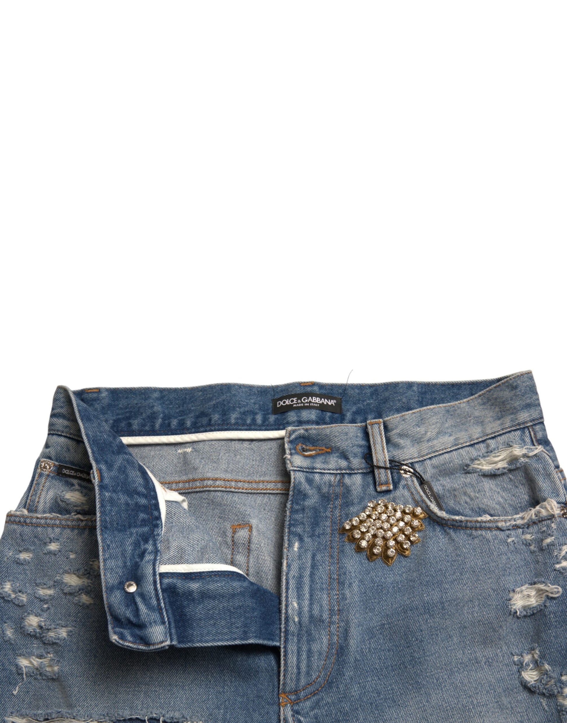 Blue denim shorts with distressed details and a small embellishment on the right leg