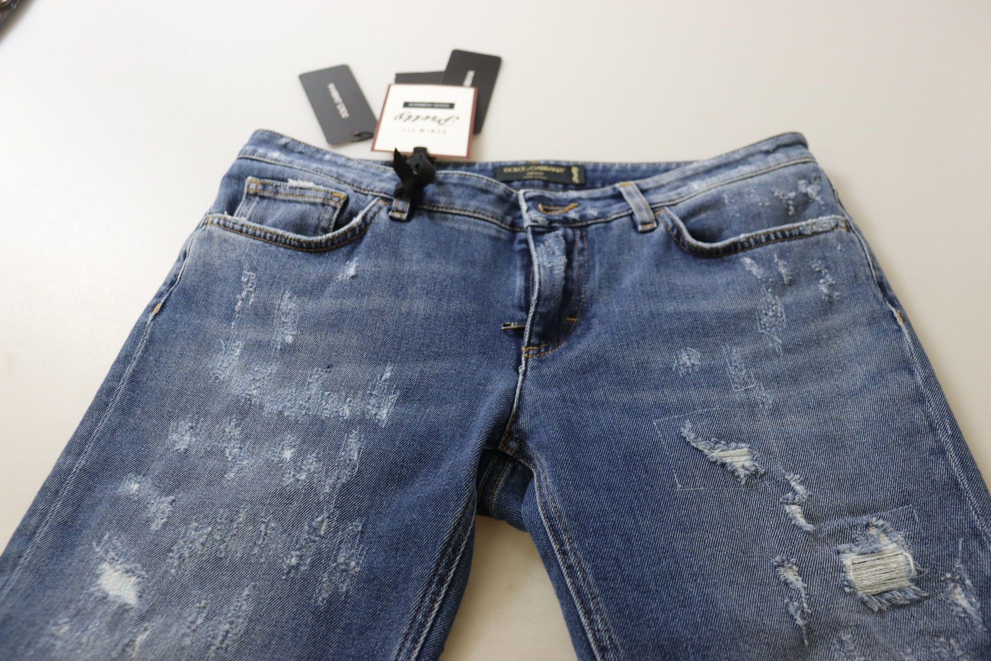 Blue denim jeans with distressed areas on legs