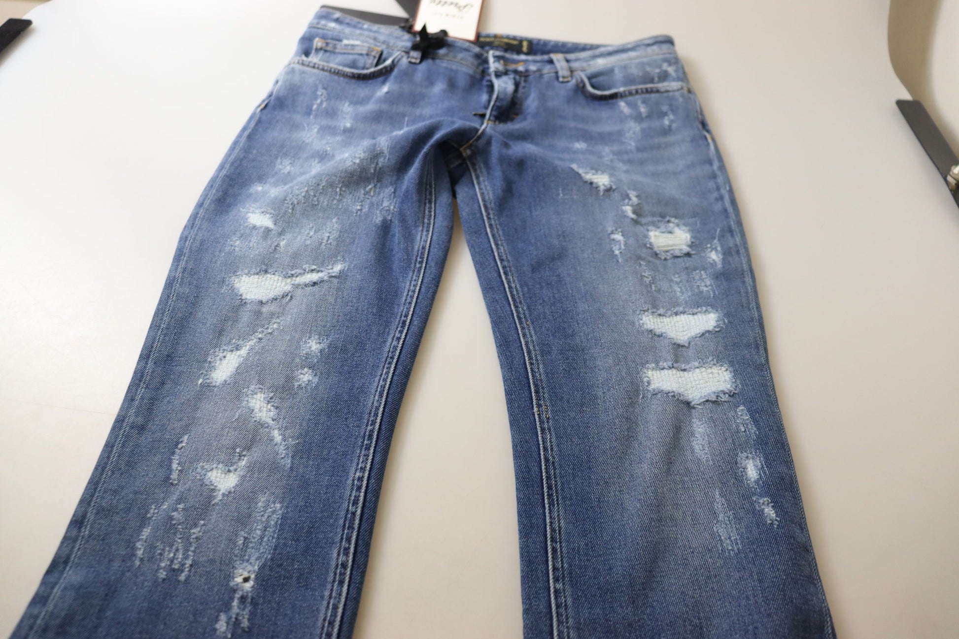 Pair of blue jeans with distressed areas on legs