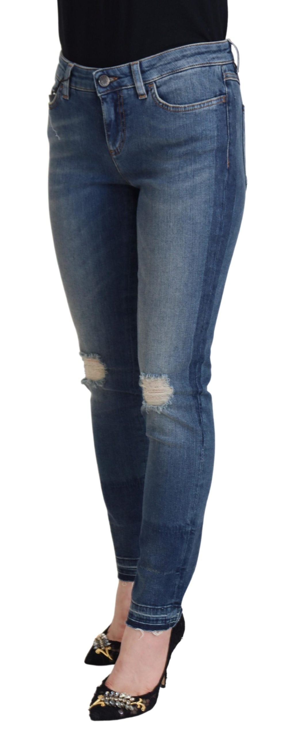 Woman wearing blue jeans with distressed areas on thighs