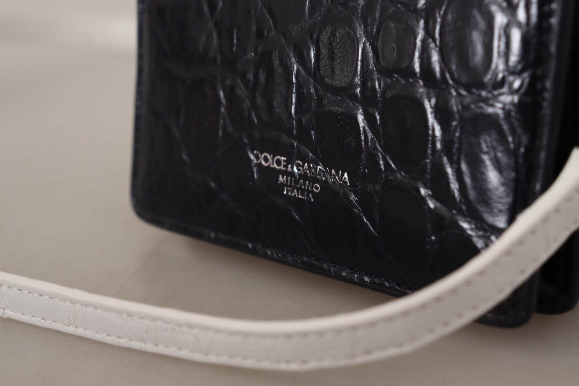 Black crocodile skin handbag with white stitching and handle