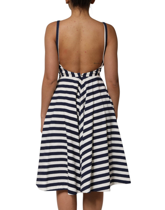 A back view of a woman wearing a blue and white striped dress with embroidery
