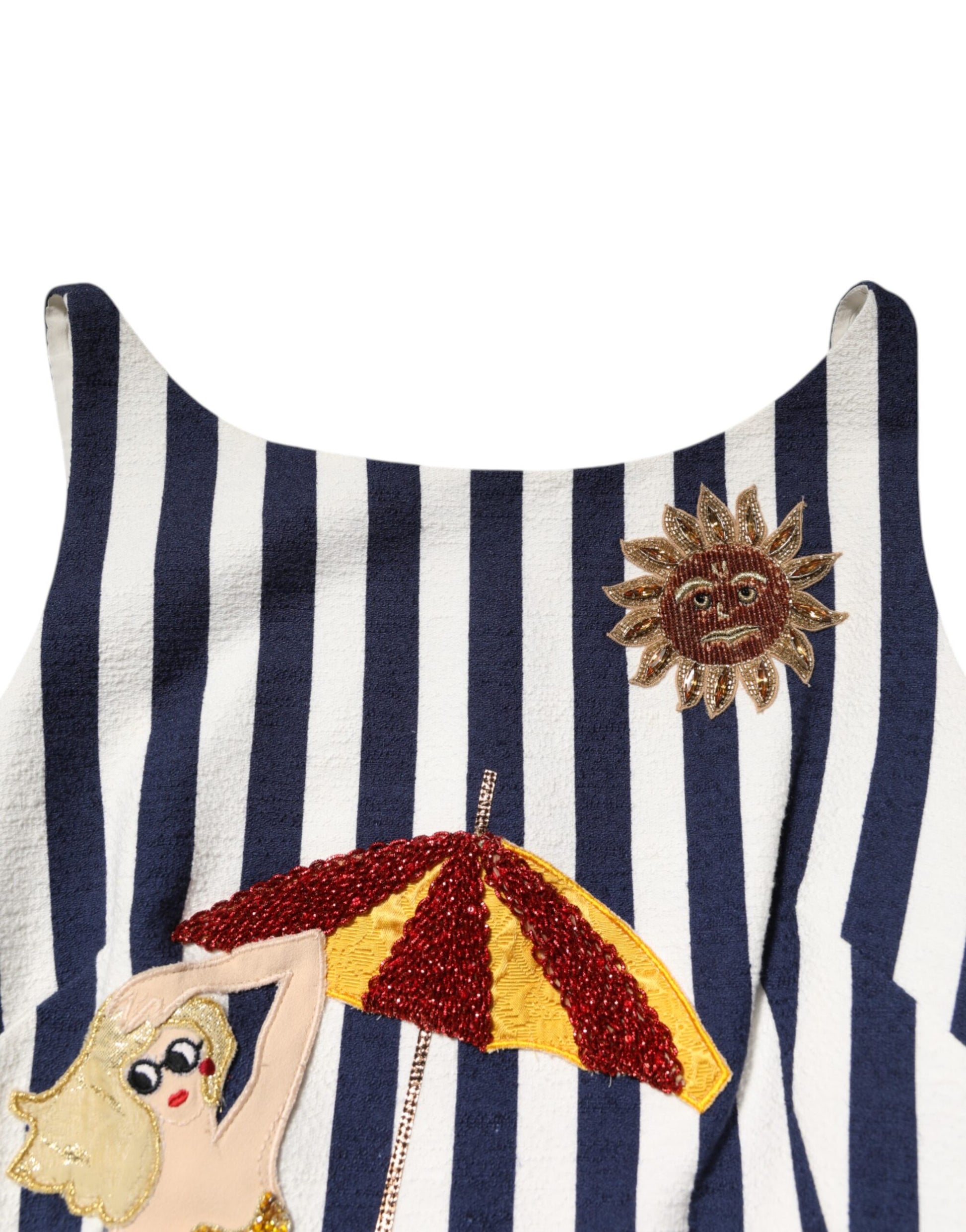 A blue and white striped dress with embroidery featuring a woman holding an umbrella