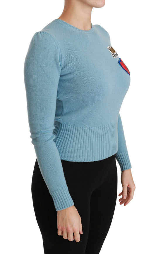Woman wearing blue sweater with ribbon on left shoulder