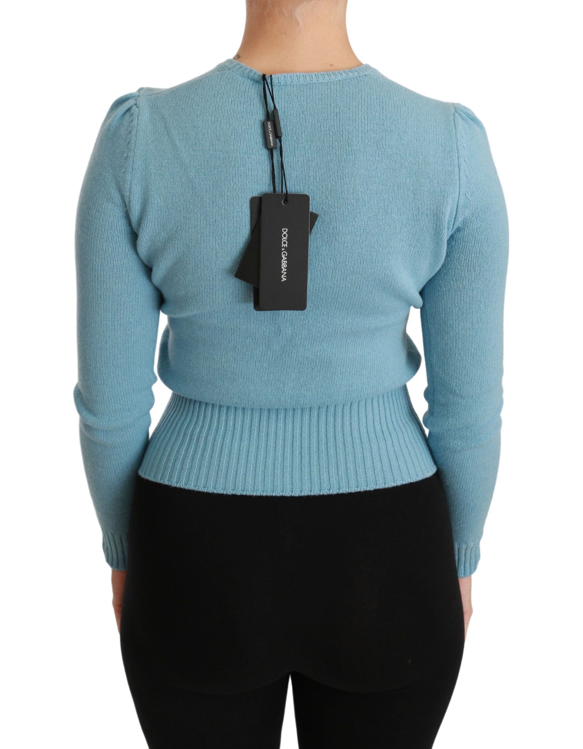 Woman wearing blue sweater with tag on back