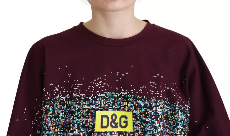 Woman wearing maroon sweatshirt with yellow D&G logo