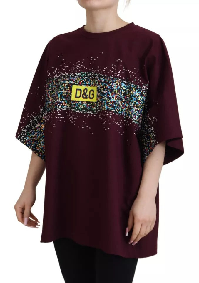 Woman wearing maroon shirt with yellow tag on front