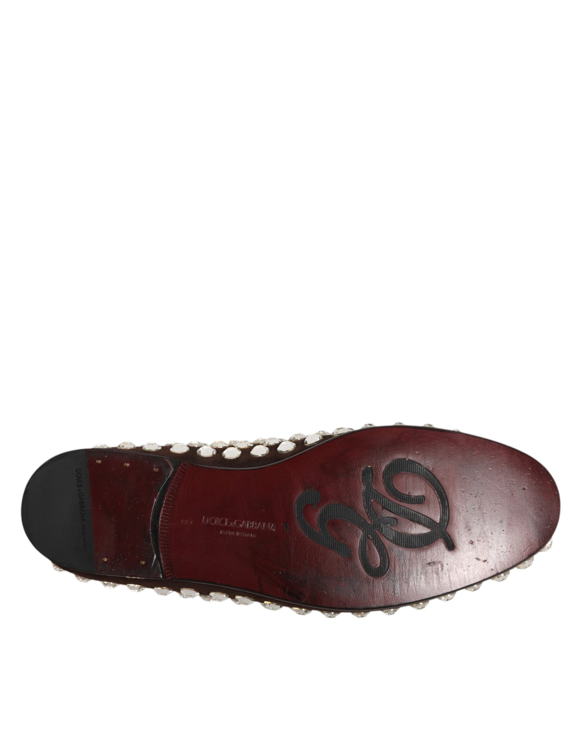 A single red loafer shoe with a suede texture and crystal embellishments