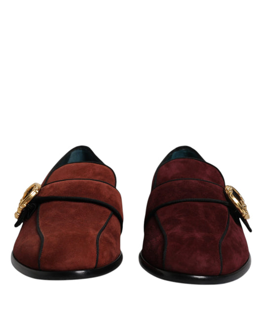 Pair of red suede loafers with black soles, featuring gold buckles and laces