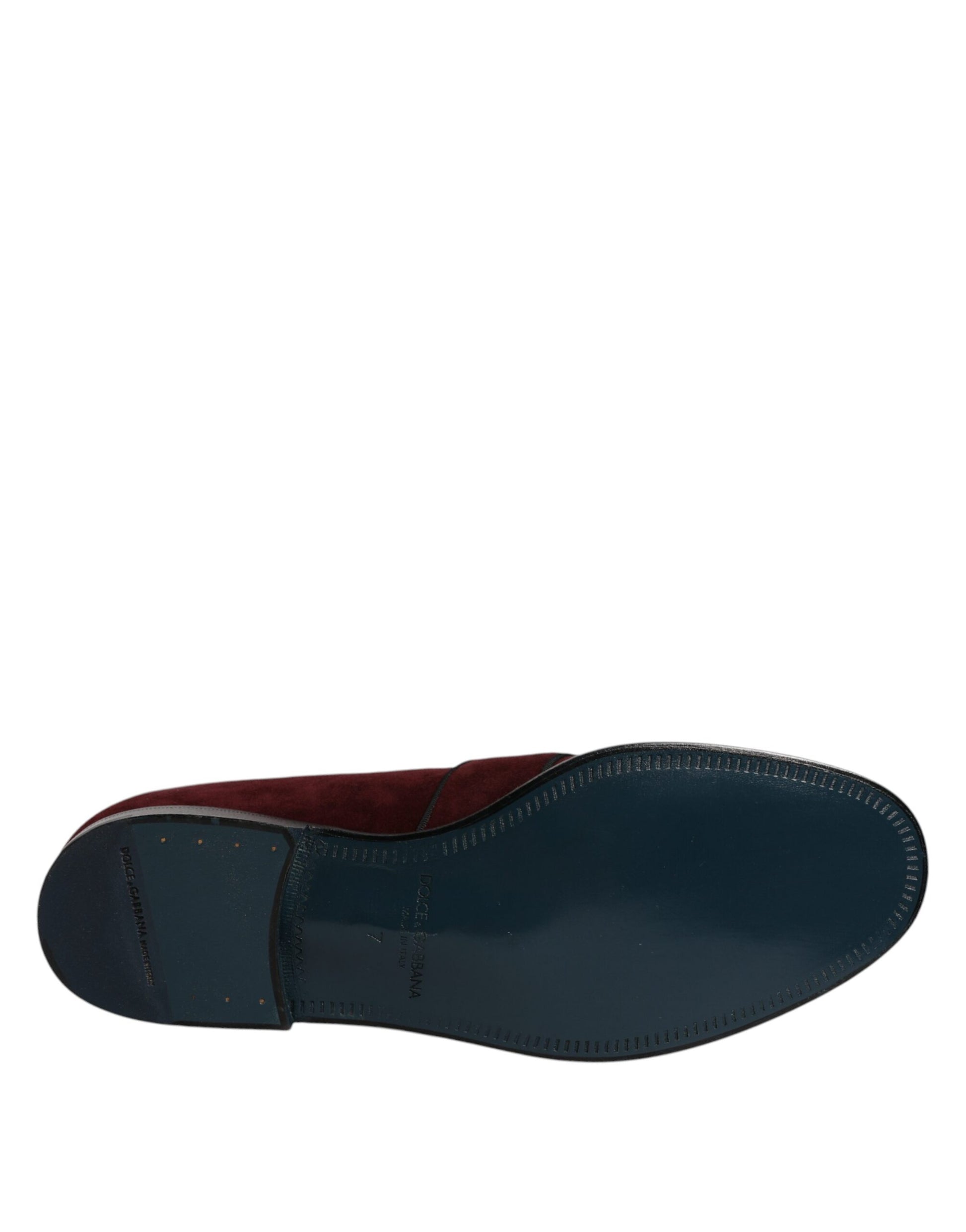 A single shoe, featuring a dark blue suede upper with red accents and a black sole