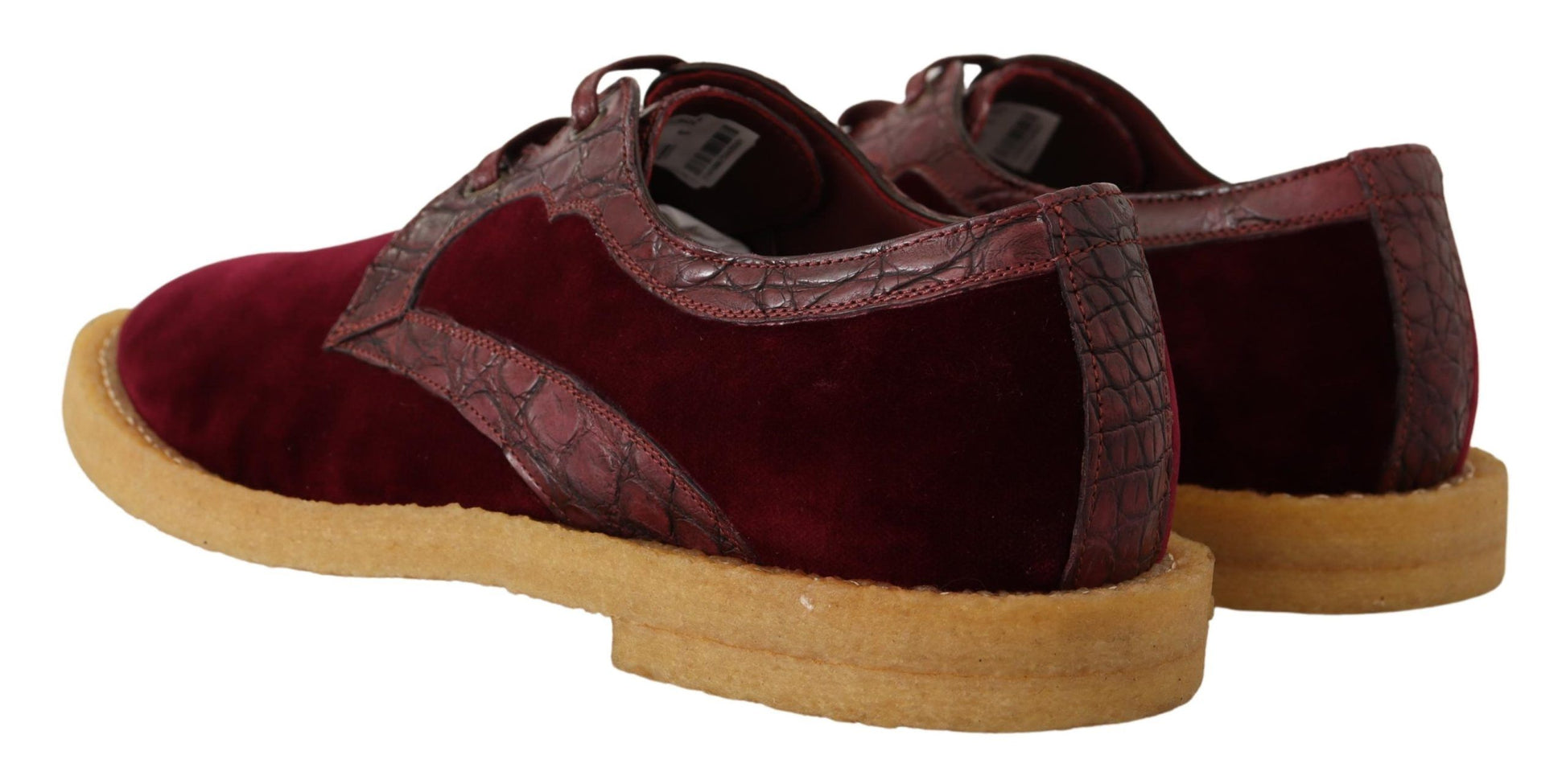 Pair of burgundy velvet shoes with tan soles and laces