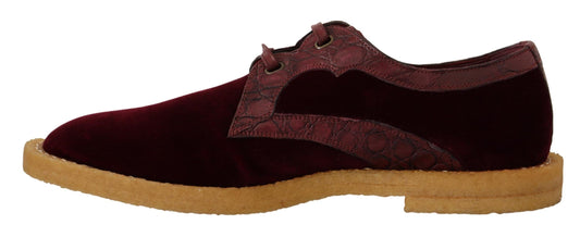 Pair of burgundy velvet shoes with tan soles and laces