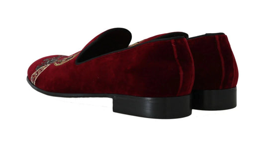 Pair of red velvet loafers with black soles and gold accents