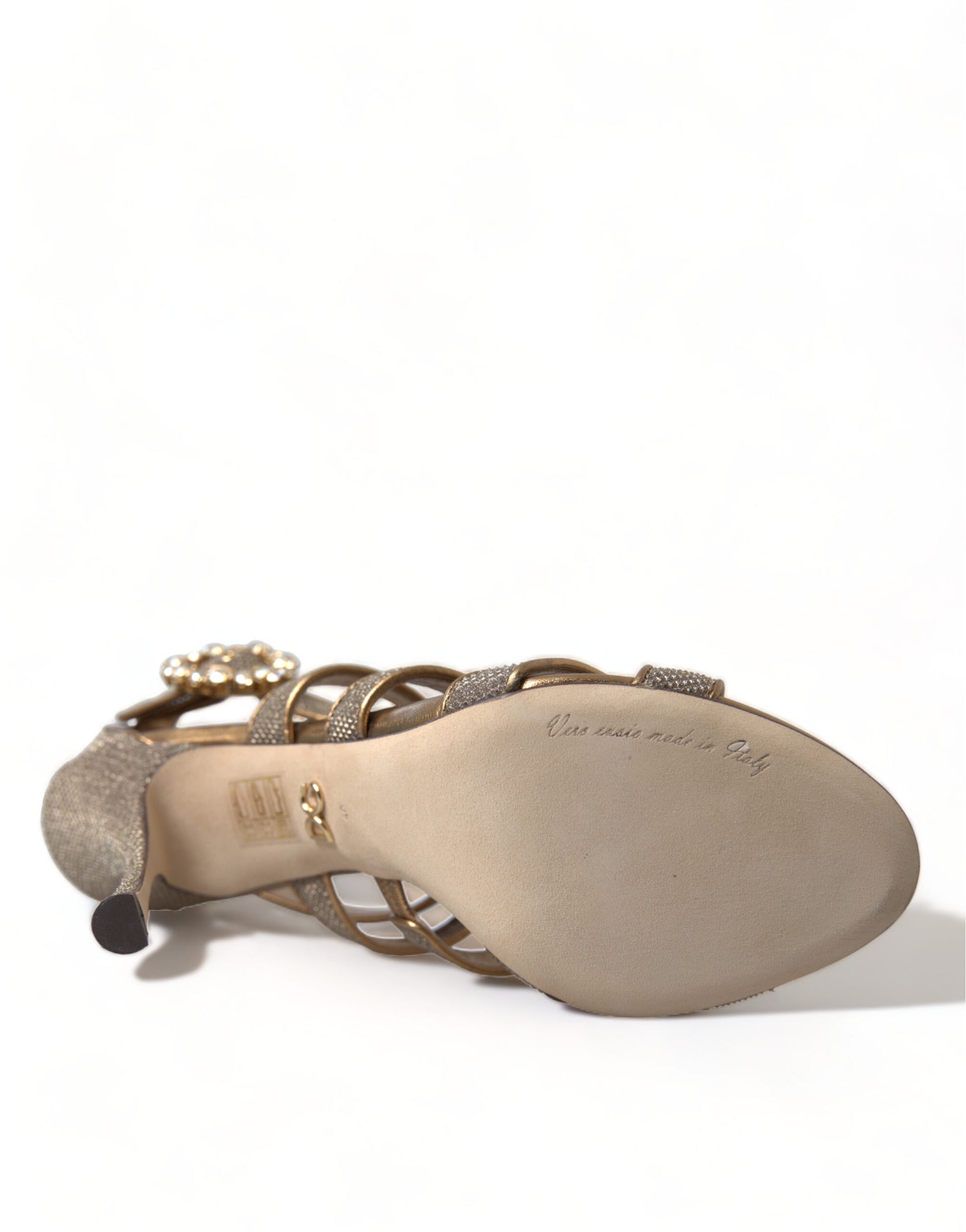 Tan high heel shoe with embellishments and a strap over the toe