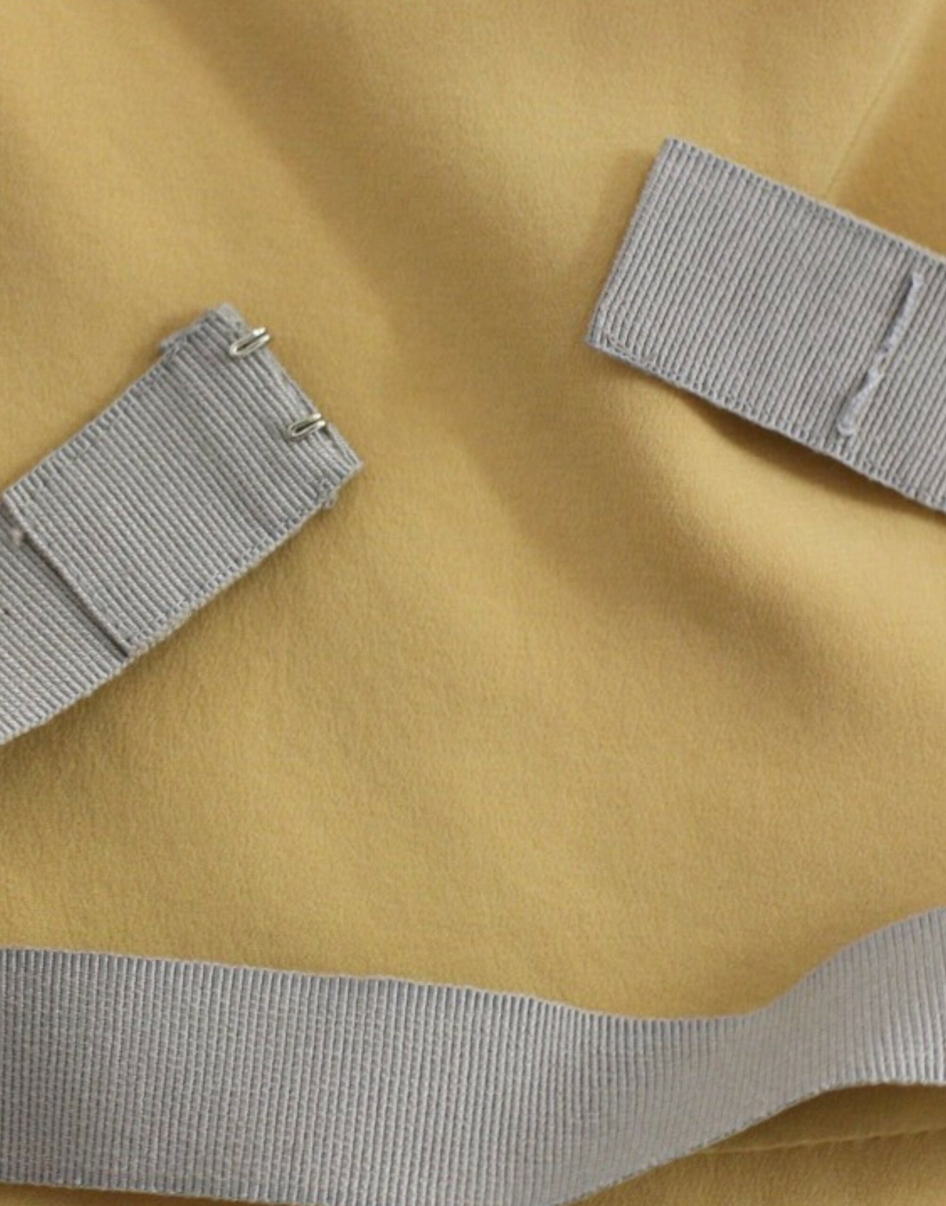 Grey fabric straps on yellow fabric