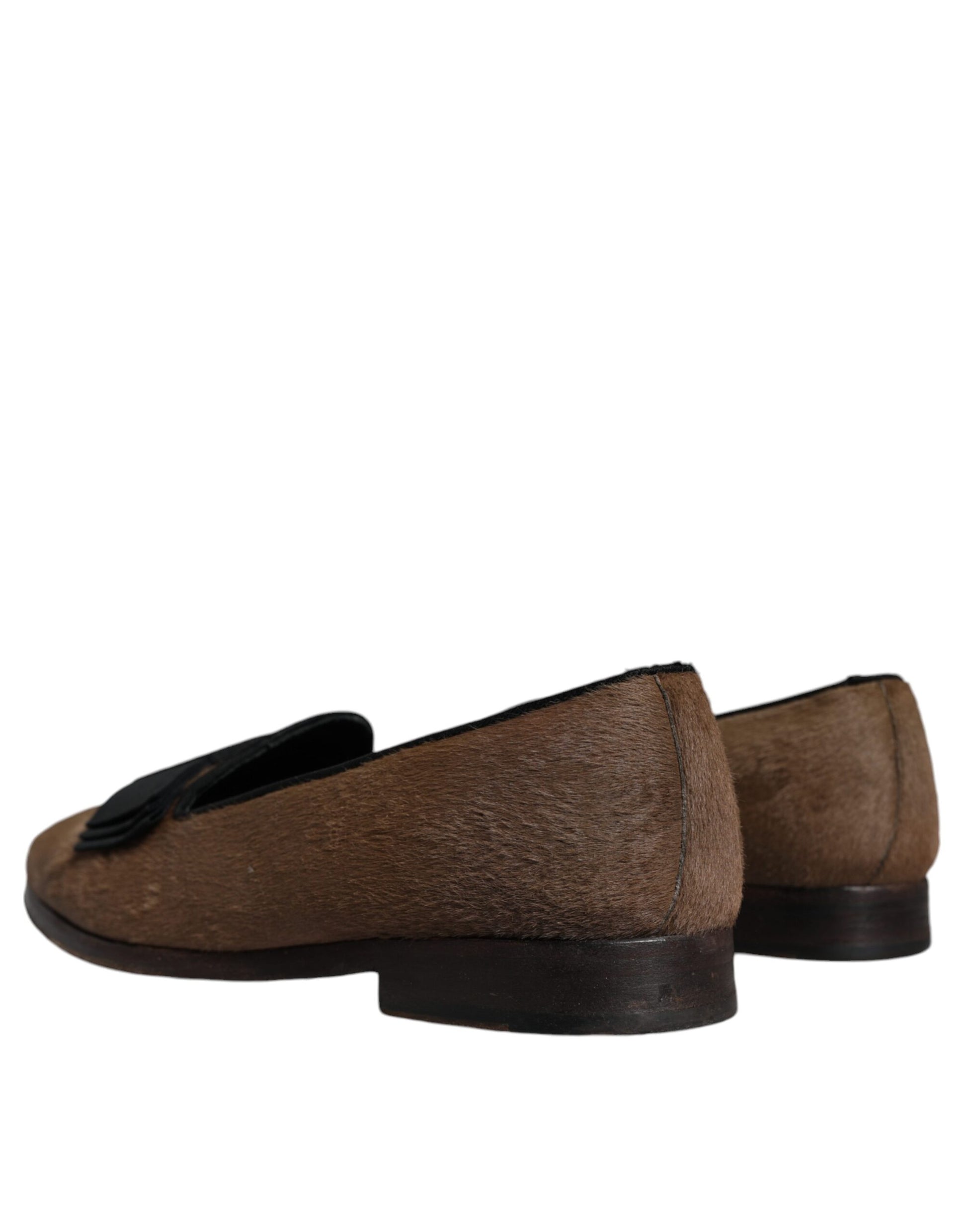 Pair of brown leather loafers with black soles, featuring a bow on the side