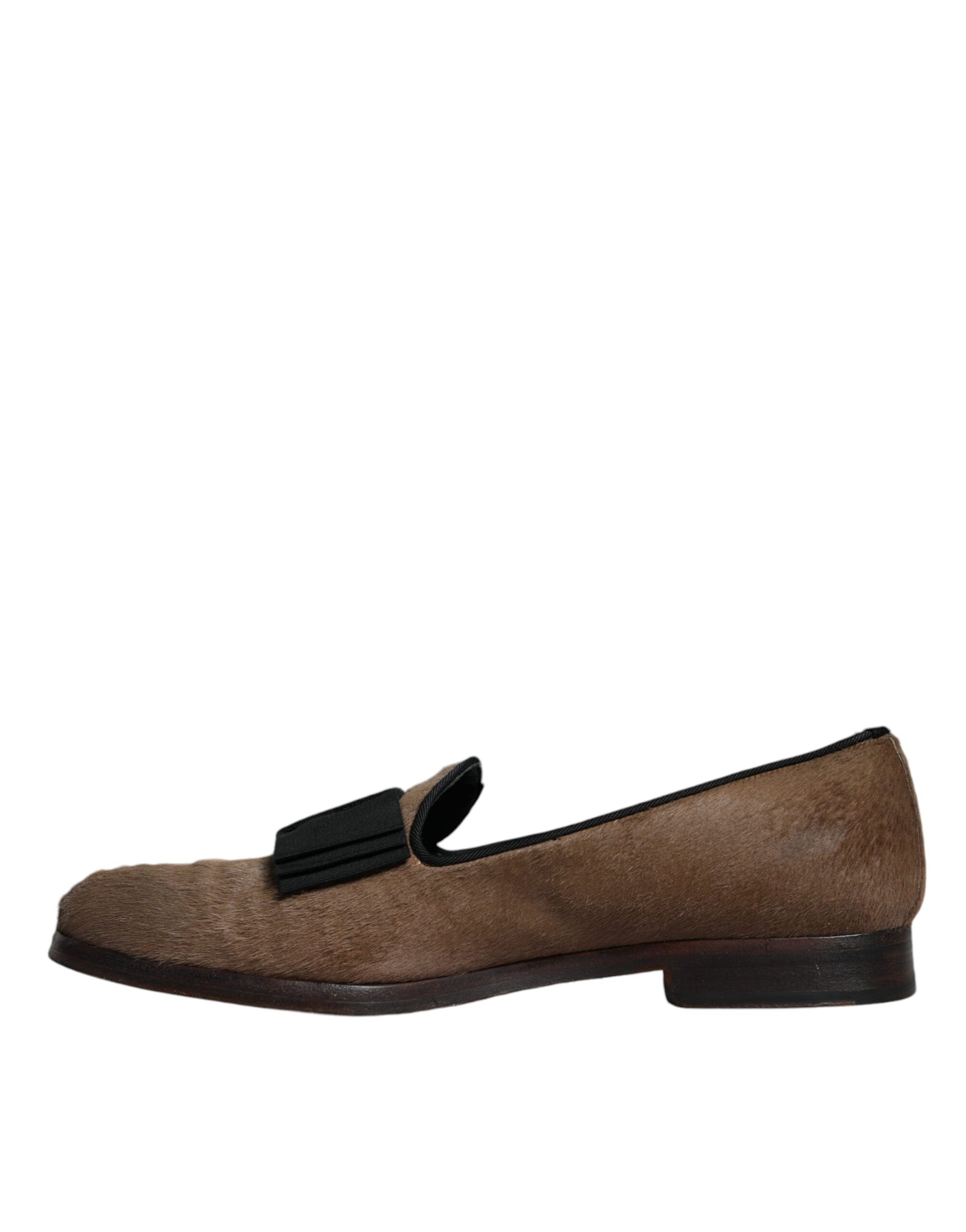 A pair of brown leather loafers with a black strap, designed by Dolce & Gabbana