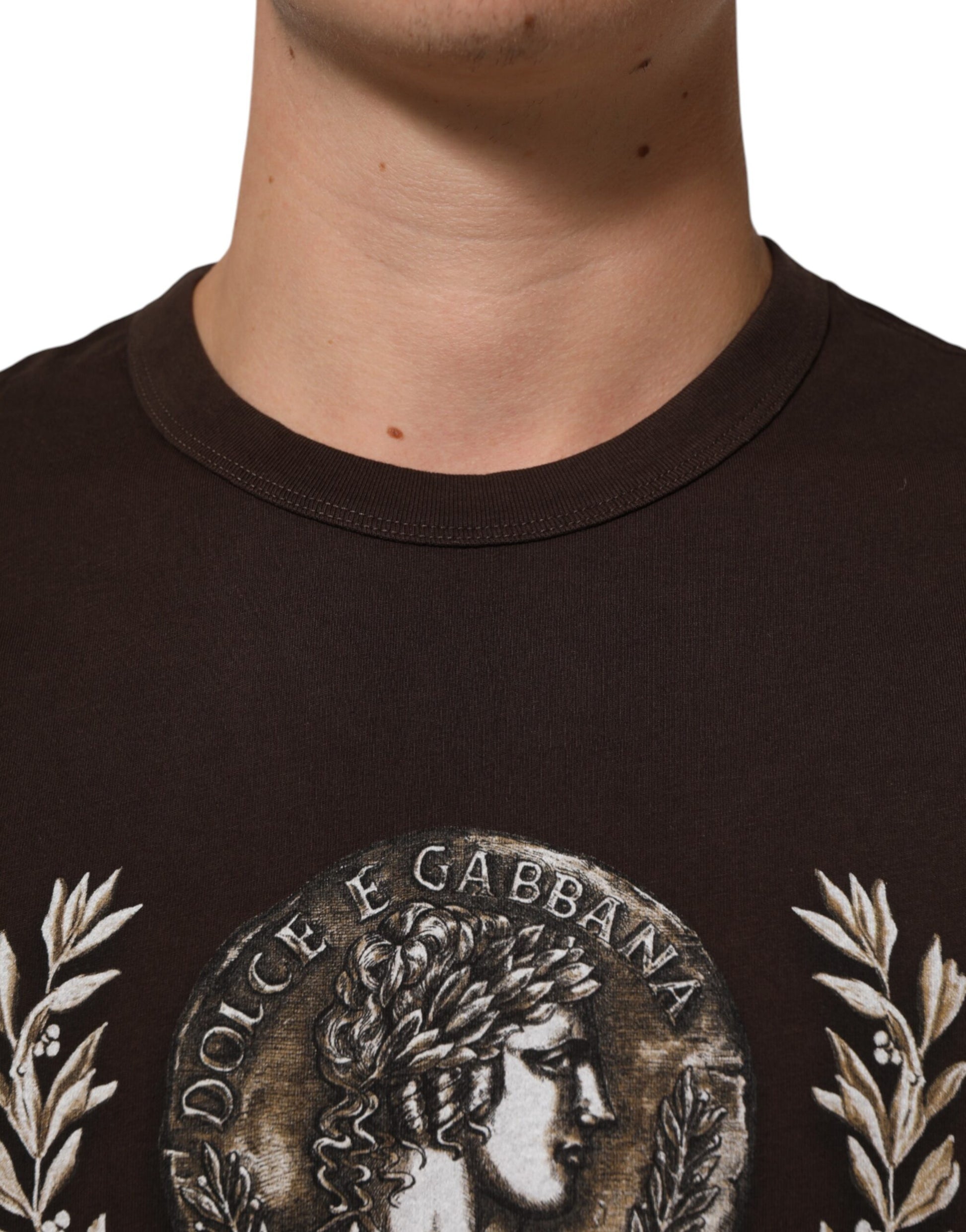 Man wearing brown shirt with embroidered emblem on chest
