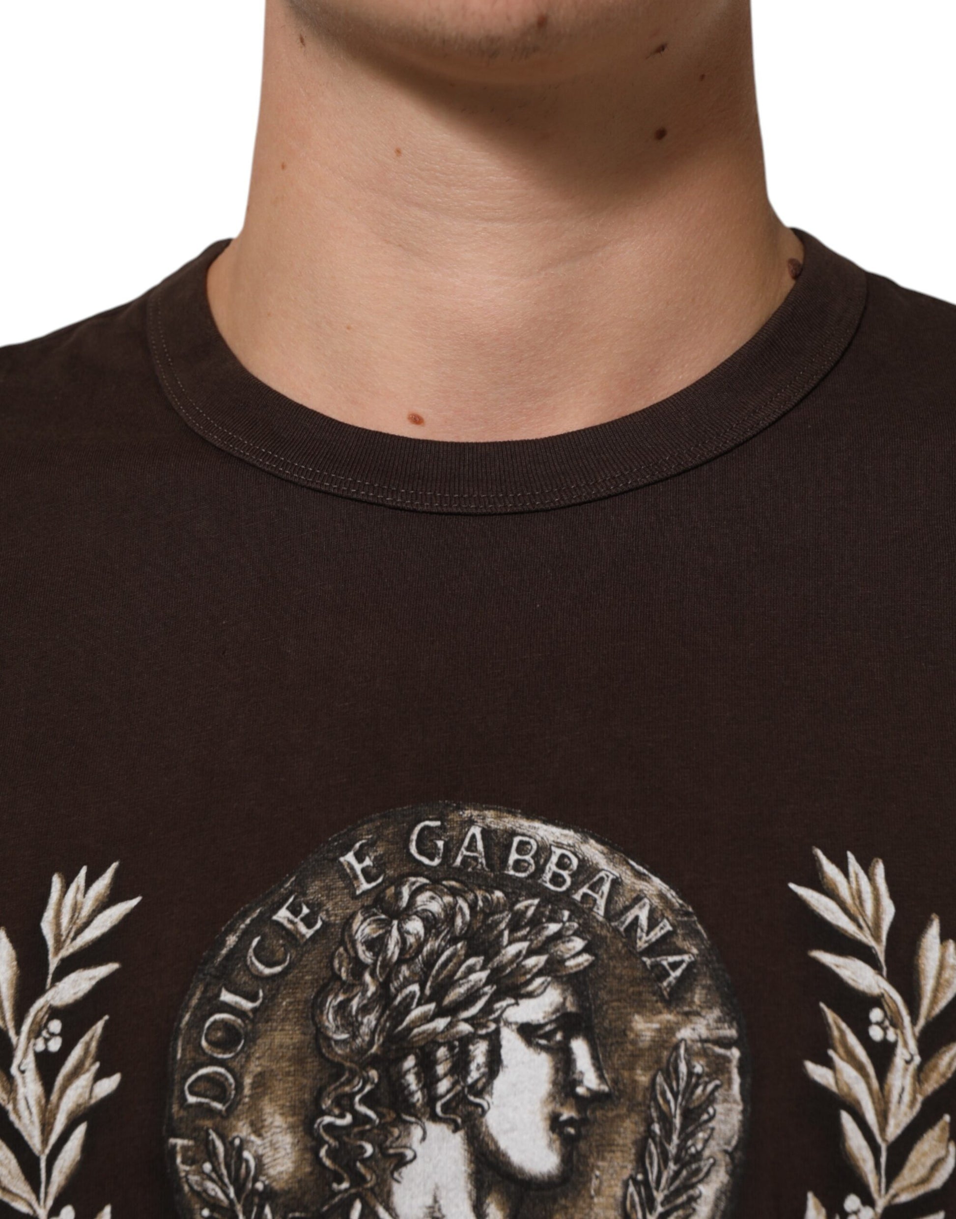 Man wearing brown shirt with embroidered emblem