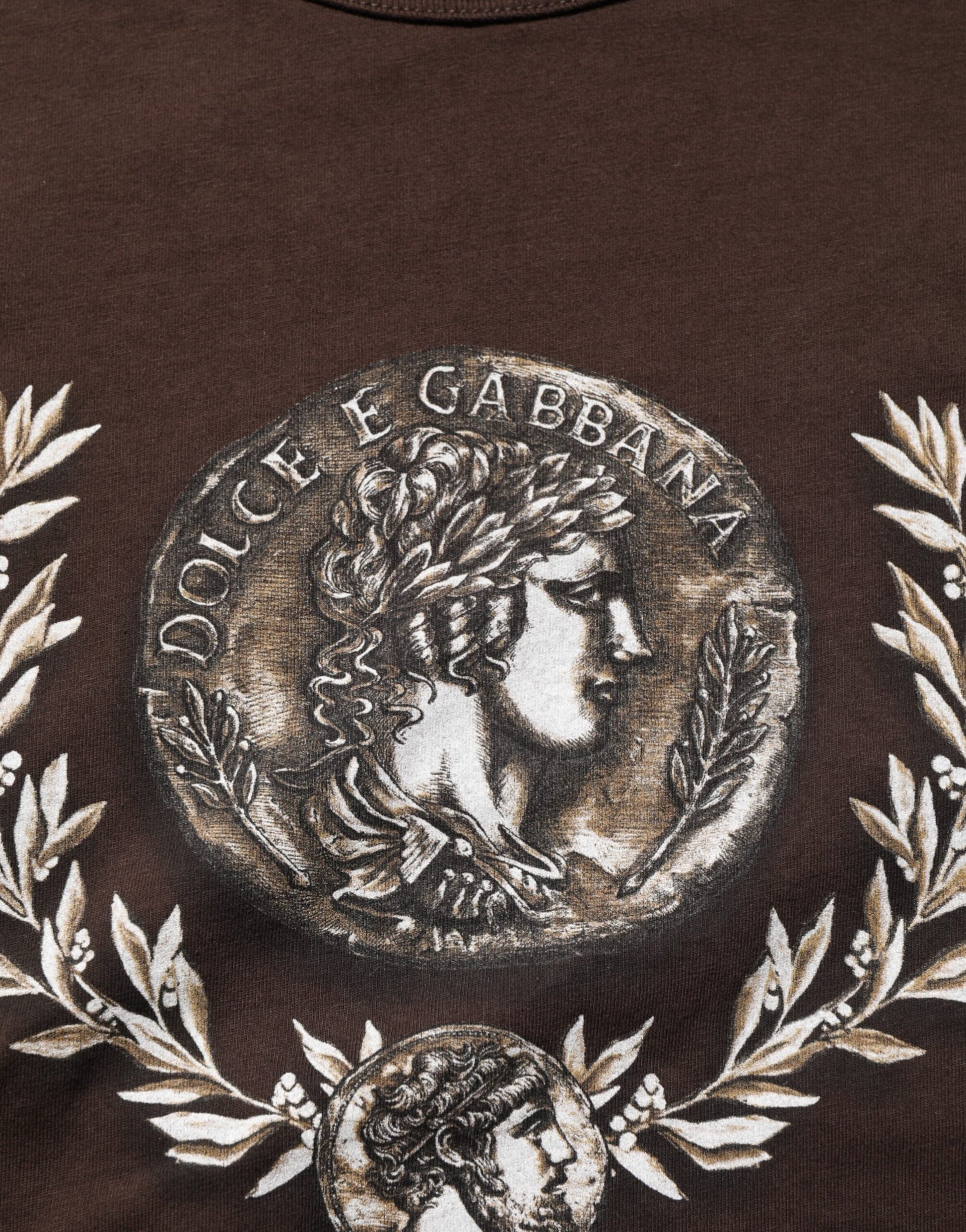 Embroidered emblem on a garment featuring a profile of a man's face surrounded by laurel leaves