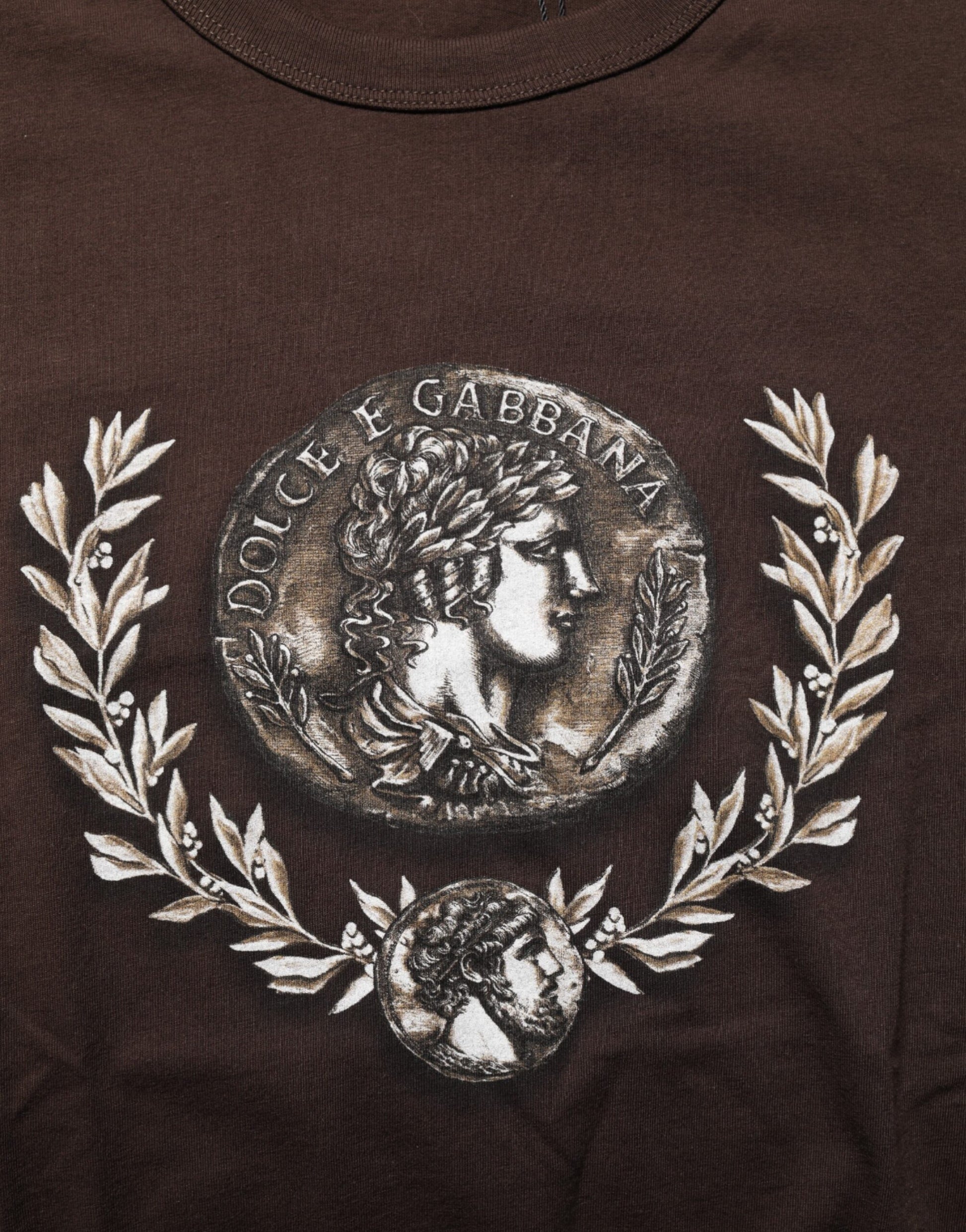 Embroidered emblem on shirt featuring profile of man's head within laurel wreath