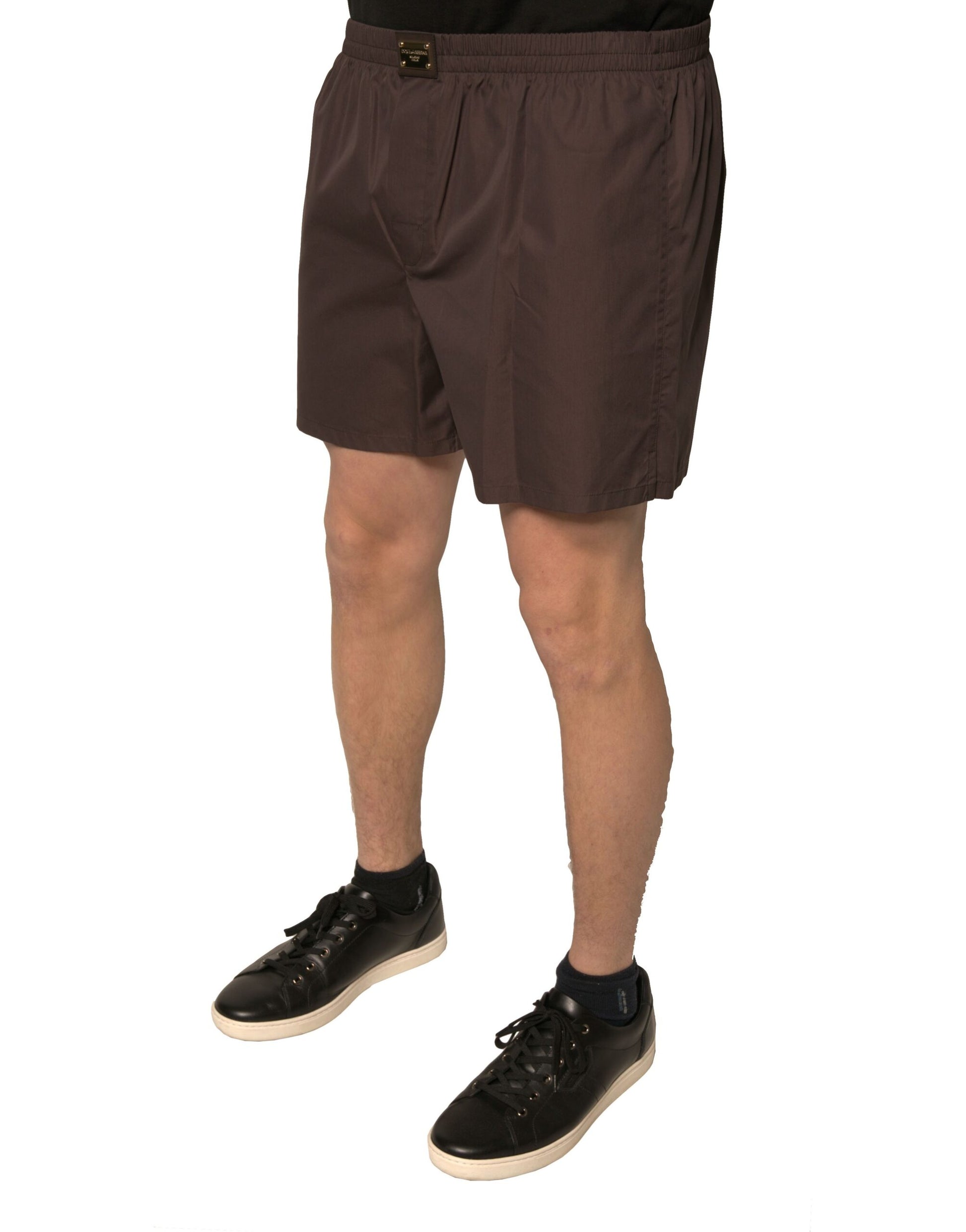 A pair of brown cotton blend men's mid waist shorts with a brand logo visible on the front