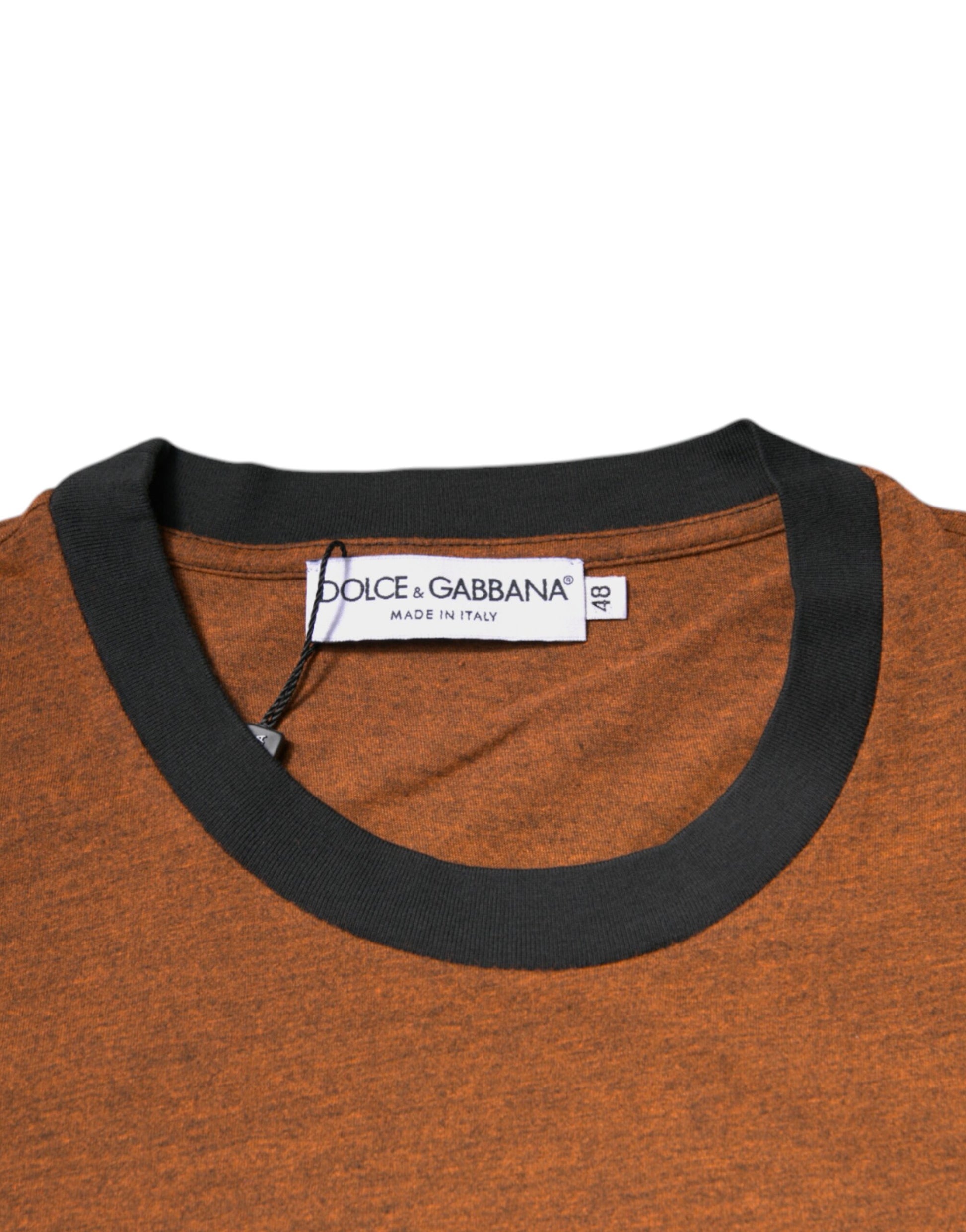 A neckline of an orange sweater with black trim