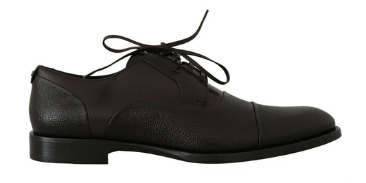 Pair of black dress shoes with laces and a bow on top