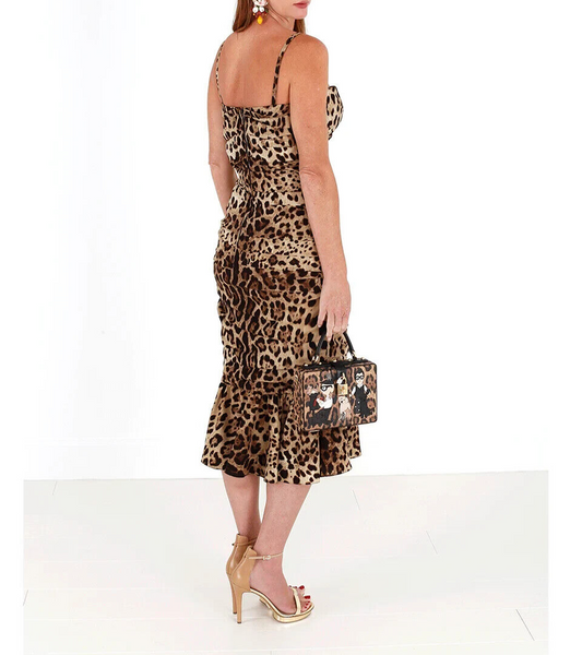 A woman wearing a brown leopard print midi dress with ruched detailing