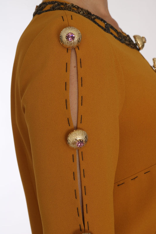 A brown dress with a crystal embellished sleeve and shoulder seam