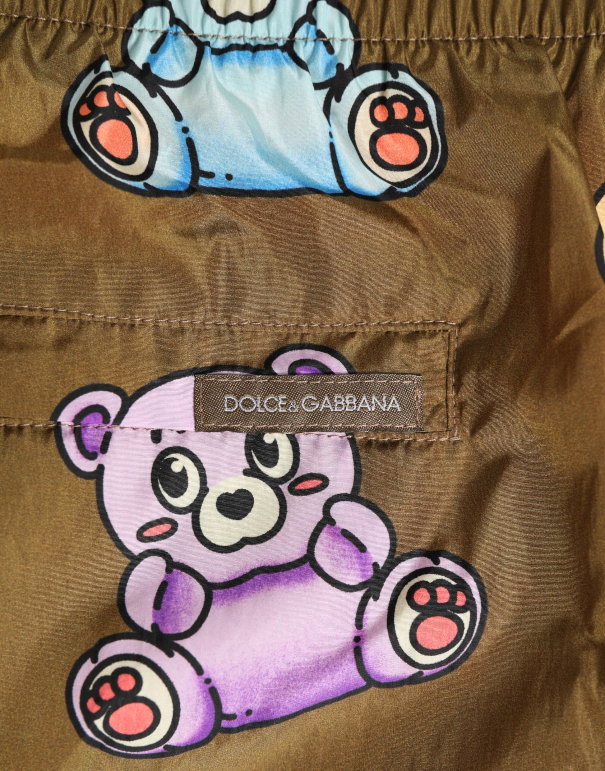 A pair of brown men's shorts with a multicolored teddy bear design