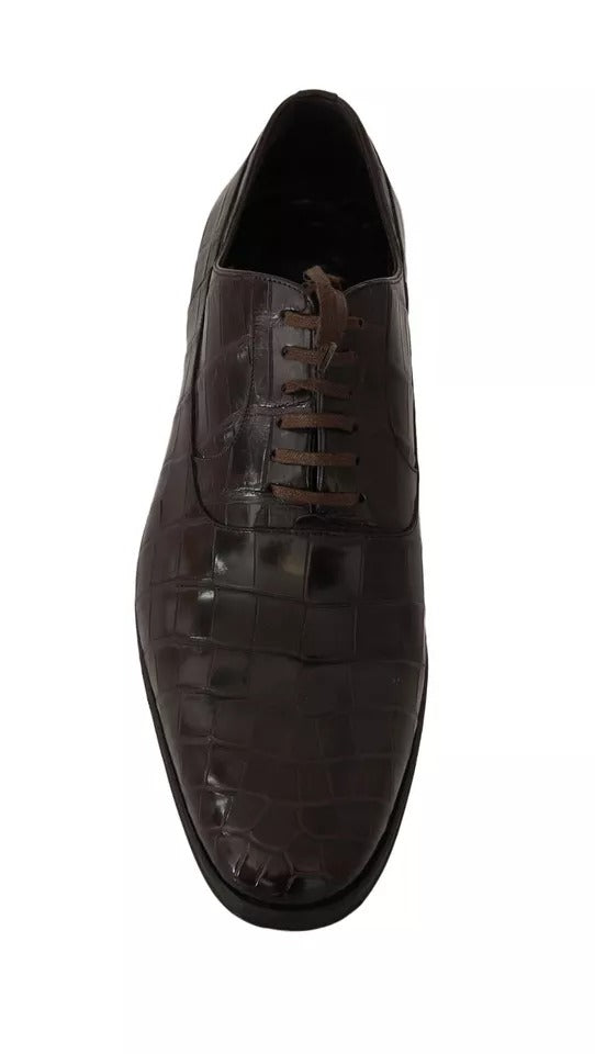 A pair of brown leather dress shoes with a patterned design, featuring laces and a shiny finish