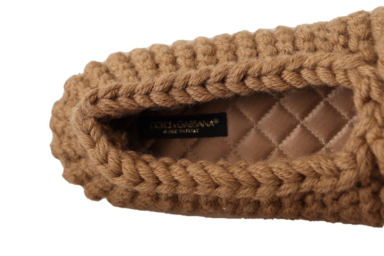 Brown slipper with braided trim and a tag inside