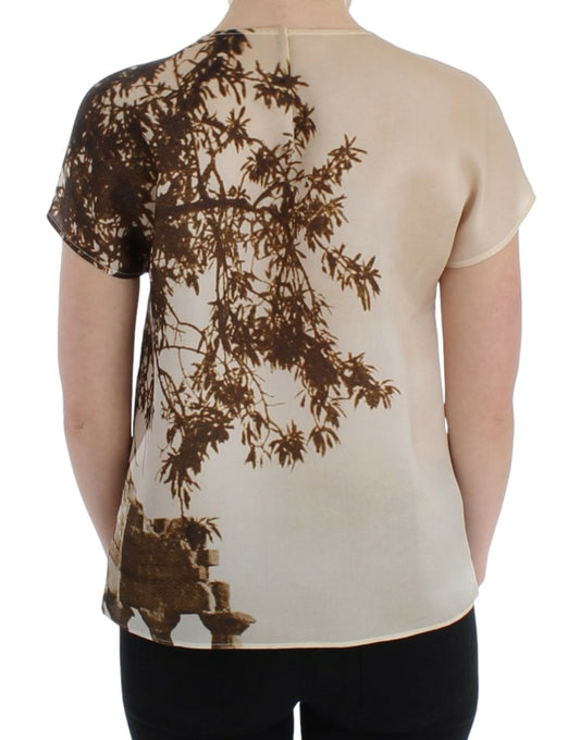 Back of a person wearing a short sleeve shirt with a tree design on it