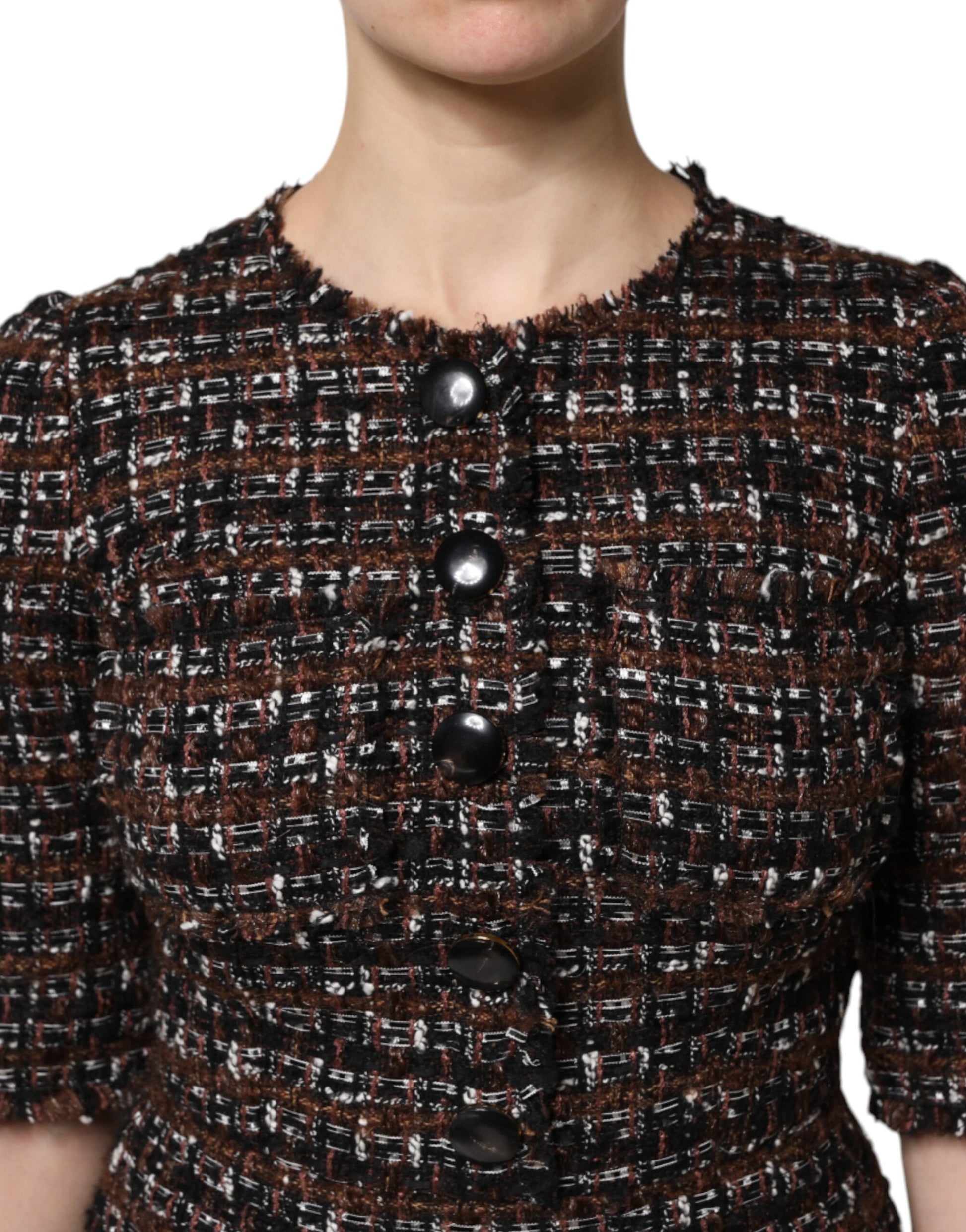 Woman wearing a brown tweed jacket with black buttons